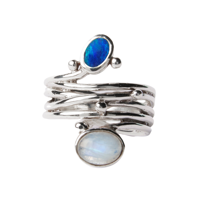 A Snake Ring in Silver Gold & various gemstones by Gallardo & Blaine Designs features a unique design with multiple parallel bands and is adorned with two gemstones. One gemstone is an oval blue opal, and the other is an oval moonstone with a soft, milky appearance. This elegant piece stands out as an adjustable silver & gold ring.