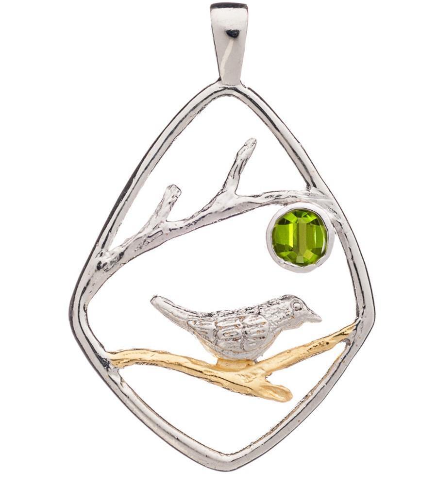 An elegant Song Bird Pendant by Gallardo & Blaine Designs featuring a song bird perched on a golden branch within a diamond-shaped sterling silver frame. A green gemstone is set inside, depicting a sun or moon. Delicate branches extend across the design, adding to the intricate detail.