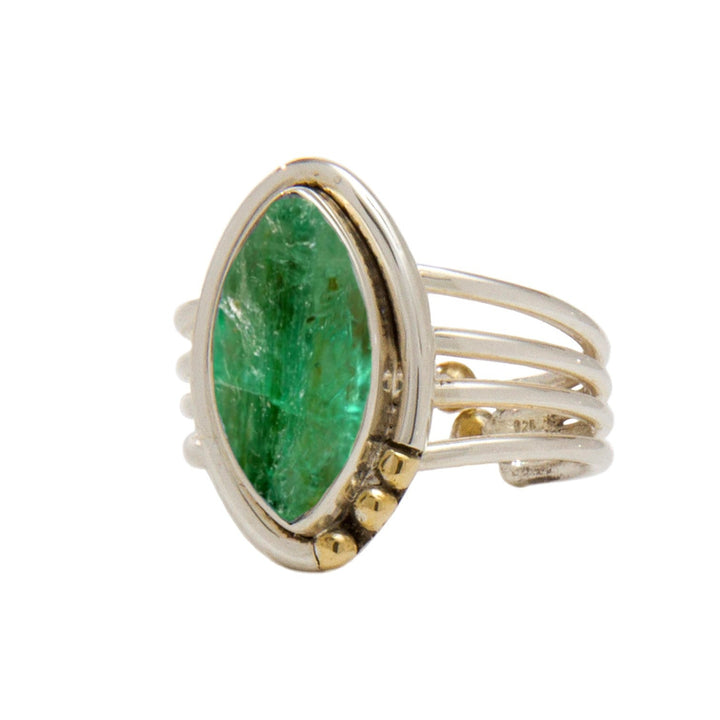 A Tulip Ring in various gemstones featuring a large, marquise-cut green gemstone set in a modern, multi-band, silver and gold setting. The bands are intertwined, with gold accents near the base of the gemstone. The ring from Gallardo & Blaine Designs has a contemporary and elegant design.