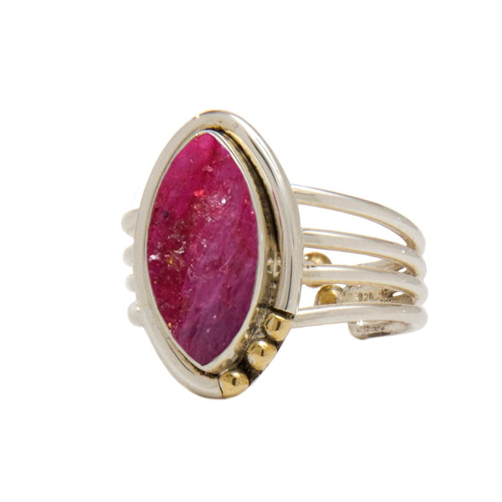 A gold, Art Deco adjustable ring featuring a large, oval-shaped pink gem set vertically in the center. The ring band consists of multiple thin, parallel bands joined together, with small gold accents on either side of the gemstone. This exquisite piece is known as the Tulip Ring in various gemstones by Gallardo & Blaine Designs.