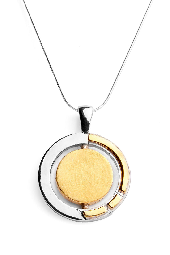 The Urú Large Pendant & Chain from Gallardo & Blaine Designs features a circular two-tone pendant, showcasing a sterling silver & gold vermeil outer ring with an Irish heritage jewelry-inspired inner circle. The Celtic pendant necklace hangs from a thin, sleek silver chain. The background is plain white.