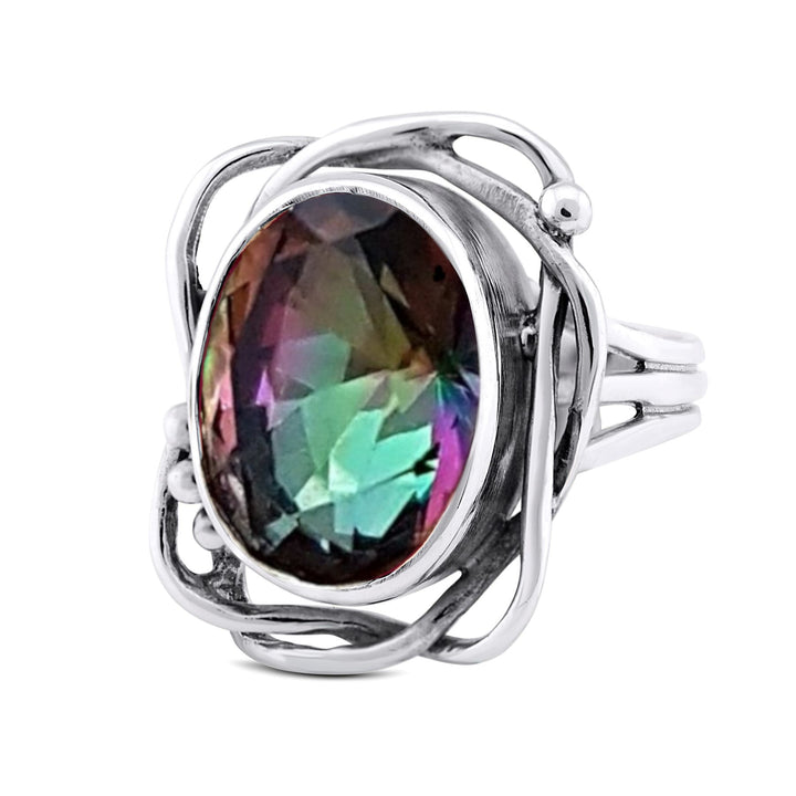 A silver ring featuring an oval-shaped, faceted gemstone with iridescent colors of purple, green, and blue. The intricate, swirling silver setting surrounds the gemstone, creating an elegant and artistic design. This adjustable **Whirlpool Ring in various gemstones** by **Gallardo & Blaine Designs** offers both beauty and versatility.