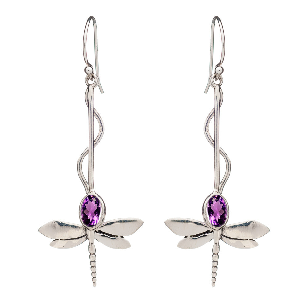 A pair of Willow Earrings in Various Gemstones by Gallardo & Blaine Designs with elongated hooks. The dragonflies boast detailed wings and bodies, featuring oval-shaped purple gemstones set in their centers. The twisted pattern of the hooks elegantly leads to the shimmering dragonfly design.