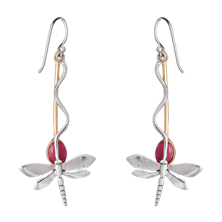 The Willow Earrings in Various Gemstones by Gallardo & Blaine Designs are a pair of dangle earrings designed to resemble silver dragonflies, featuring silver-toned bodies with gold-toned accents and red oval-shaped gemstones as the rear part of the bodies. The earrings have hook attachments for wearing.