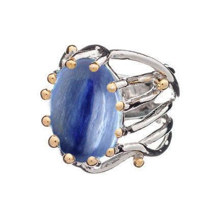 An oval-shaped blue gemstone adjustable ring with a polished silver band featuring an intricate, openwork design. Small gold beads accent the edges of the gemstone, enhancing the overall elegance and sophistication of this Willow Ring in various gemstones by Gallardo & Blaine Designs.