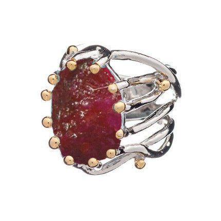 Introducing the Willow Ring in various gemstones by Gallardo & Blaine Designs, an eye-catching chunky statement gemstone ring. This adjustable silver piece showcases a large, rough-cut red gemstone secured by prongs. The intricately designed band resembles intertwining branches and is accented with small golden beads.