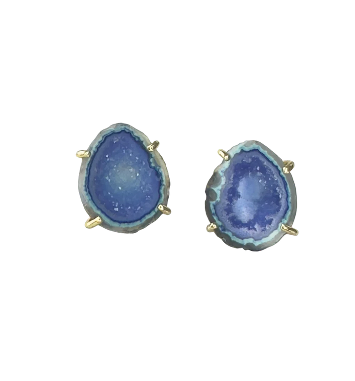 The Geode Tassel Earrings by Aria V feature irregular oval aqua blue geodes set in gold prongs, shown against a plain white background.