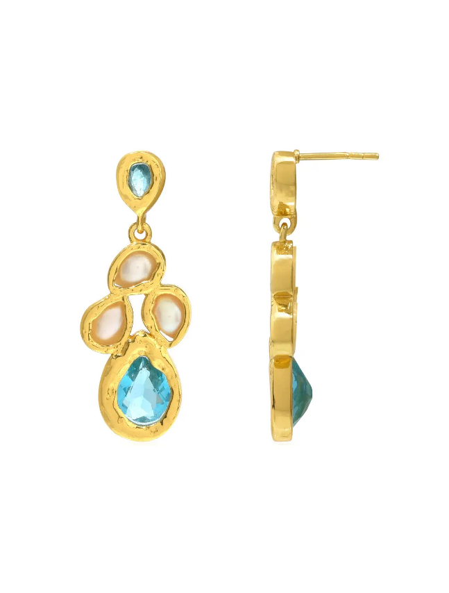 The Illian Earrings by Shyla are gold plated drop earrings adorned with blue gemstones and subtle pearly accents, displayed from both front and side views. Their organic, handcrafted design features bezel-set stones, reminiscent of refined turquoise and pearl jewelry.