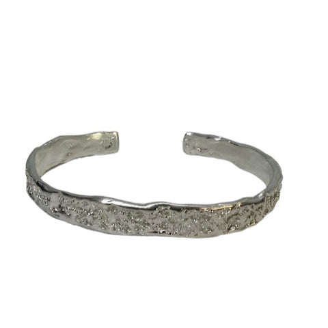 The Crackle Texture Bangle by Georgia Charal, shown in silver with a textured surface and open back, is a handmade cuff bracelet displayed on a white background. Also available in gold.