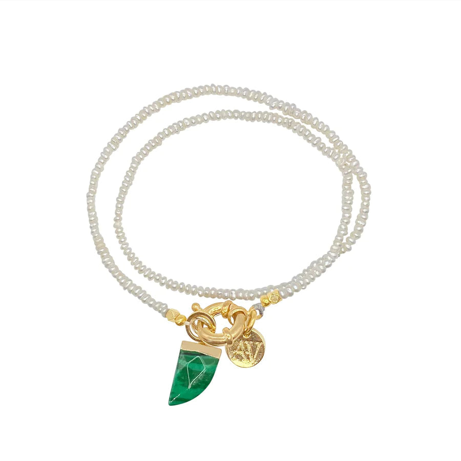 A delicate double-strand choker-style necklace featuring small, white beads. It includes two gold charms: a malachite spear stone cut in a geometric shape and a round gold coin-like piece. The charms are attached to a gold clasp and are designed to rest at the front when worn. This is the Siren Malachite Choker/Bracelet by Aria V.