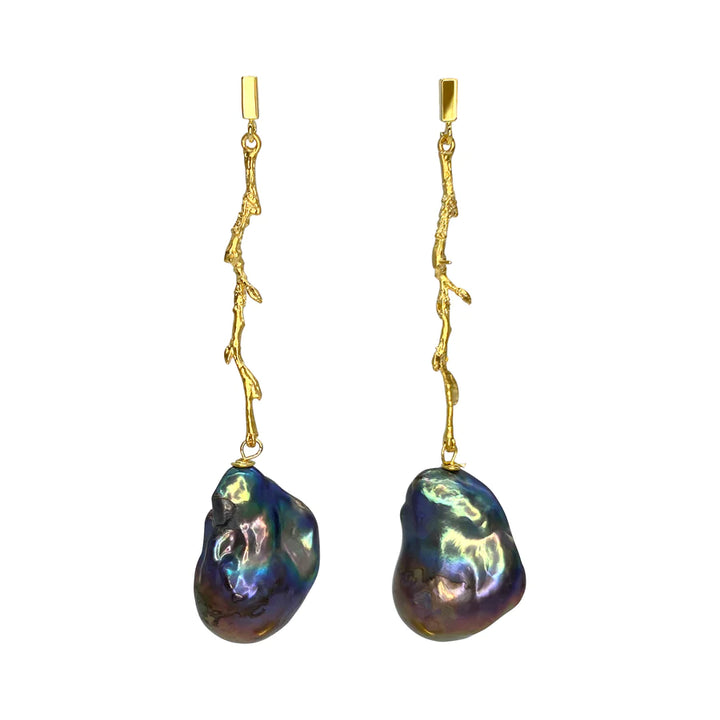 Image of a pair of Petrol Medusa Earrings by Aria V featuring elegant dangle designs with irregular-shaped, dark baroque pearls hanging from 16k gold, twig-like structures, each attached to a gold rectangular stud at the top. The pearls exhibit a multi-colored iridescent sheen.