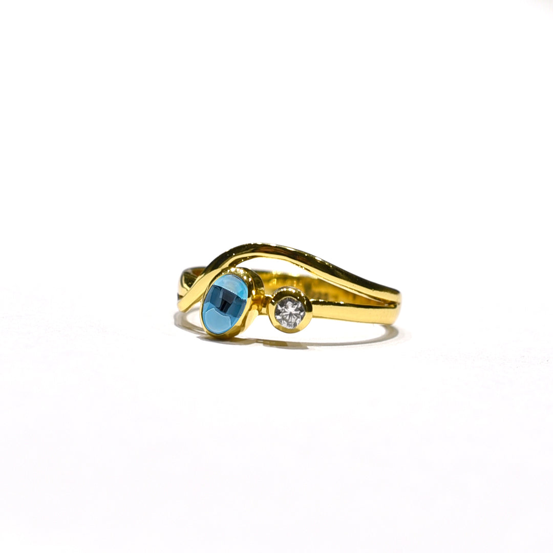 The Watermelon Tropical Iolite & Cubic Zirconia Gold Ring features a twisting gold plated sterling silver band with a round iolite and smaller cubic zirconia side by side—ideal for fans of handmade jewellery.