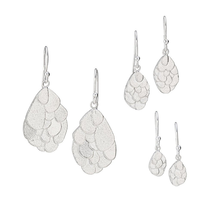 A set of three pairs of Leoma Drew Kimana Drop Earrings in Frosted Silver with a cluster design. The earrings increase in size from top to bottom, featuring a teardrop shape comprised of overlapping, textured, leaf-like segments.
