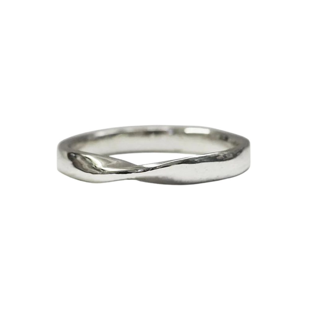 A simple silver Knot Wedding Ring with a subtle twist in its design, presented against a plain white background. The ring has a smooth and shiny finish, giving it a sleek and elegant appearance. For the perfect fit, consider using our Ring Sizing Kit from The Collective Dublin.