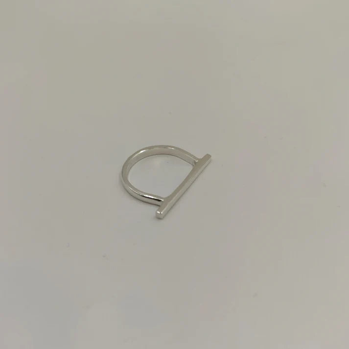 The Line Silver Ring by Inó Jewellery features a thin sterling silver band with a sleek horizontal bar, shown on a simple light background.