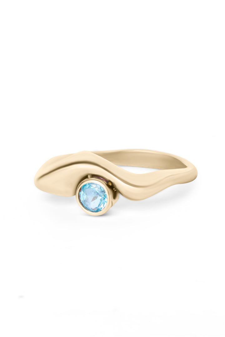The Bough Ring by Madeleine Sculptural Jewellery showcases a gold, hand-carved, organic design with a central round blue gemstone set in a bezel—an exquisite piece of modern jewellery.