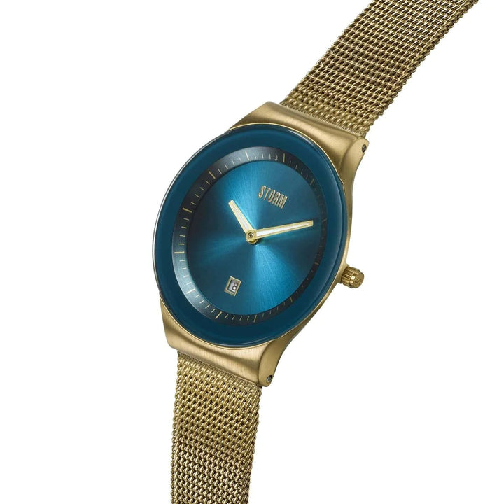 A Storm Mini Sotec Gold Teal wristwatch by Storm Watches with a blue metallic face, yellow-gold hands, and a date window at 6 o'clock. The watch features edge-to-edge glass and a matching yellow-gold mesh band and casing, with "STORM" written on the face.