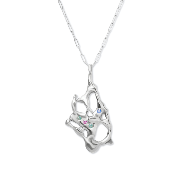 The Molten Necklace with Gemstones by Madeleine Sculptural Jewellery features an abstract, organic-shaped silver pendant with open spaces, set with pink, green, and blue gems, and hangs from a delicate chain for a unique, handmade look.