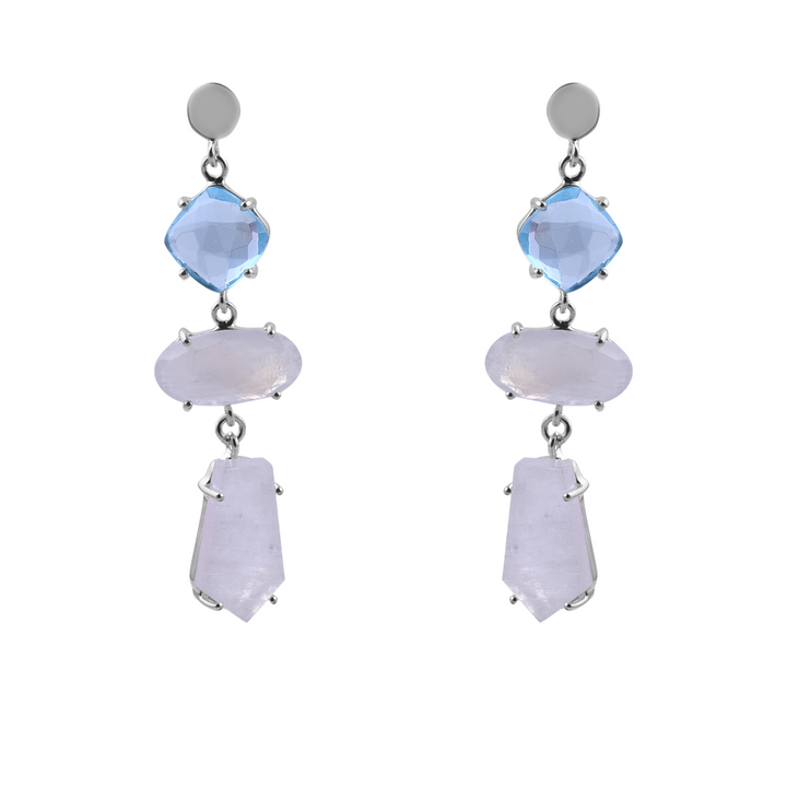 A pair of **Moonstone & Blue Quartz Silver Drop Earrings** featuring three gemstones each. The top gemstone is a blue quartz diamond shape, the middle is a light purple oval, and the bottom is a light purple elongated hexagon from **Watermelon tropical**.