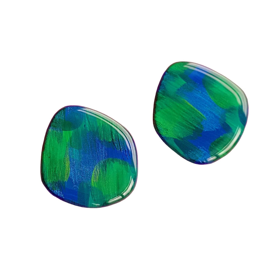 The Peacock Vibes Stud Earrings by Naoi showcase two uniquely irregularly shaped, bold hand-painted designs in vibrant blue and green abstract brush strokes. Featuring a smooth, glossy finish and stainless steel posts, these distinctive jewelry pieces bring a touch of contemporary art-inspired style. The harmonious blend of colors creates an eye-catching design.