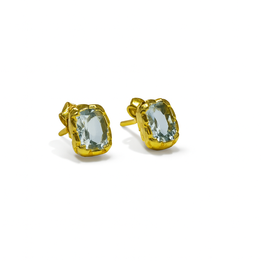 Rectangle Claw Studs by Watermelon tropical: gold plated sterling silver stud earrings with rectangular faceted light blue gemstones in gold bezels, shown on a white background.