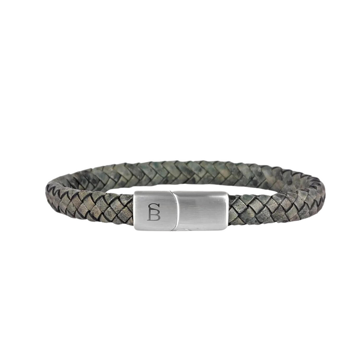 A braided leather bracelet with a branded metal clasp. The clasp, made of 316L stainless steel, features an engraved logo with the letters "B" and "F". The dark leather boasts a textured pattern. Introducing the Riley - Dark Green by Steel and Barnett.