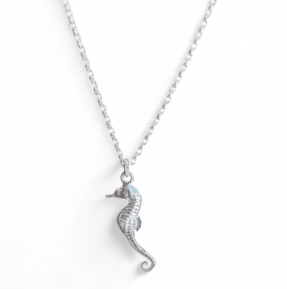 The Jennifer Kinnear Sea Horse Necklace Small Silver features a delicate sterling silver chain with a detailed seahorse pendant, displayed on a plain white background—an ideal keepsake jewelry piece.