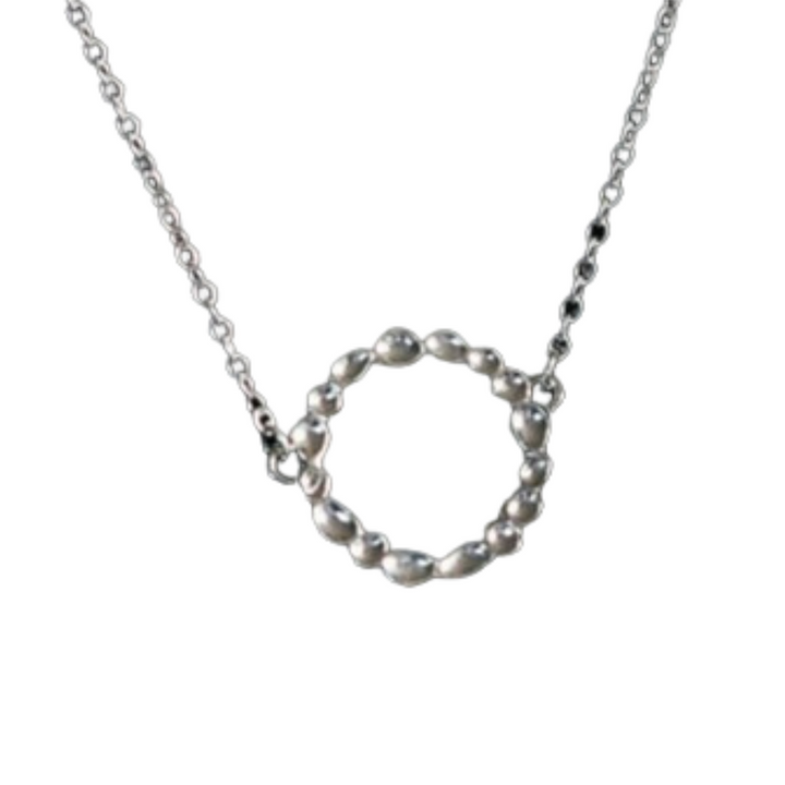 A silver necklace features a symmetrical chain with a circular pendant made of interconnected, mirror-polished metal beads. This **Sara Gunn Shimmer Circle Pendant Sterling Silver** hangs prominently at the center of the necklace.