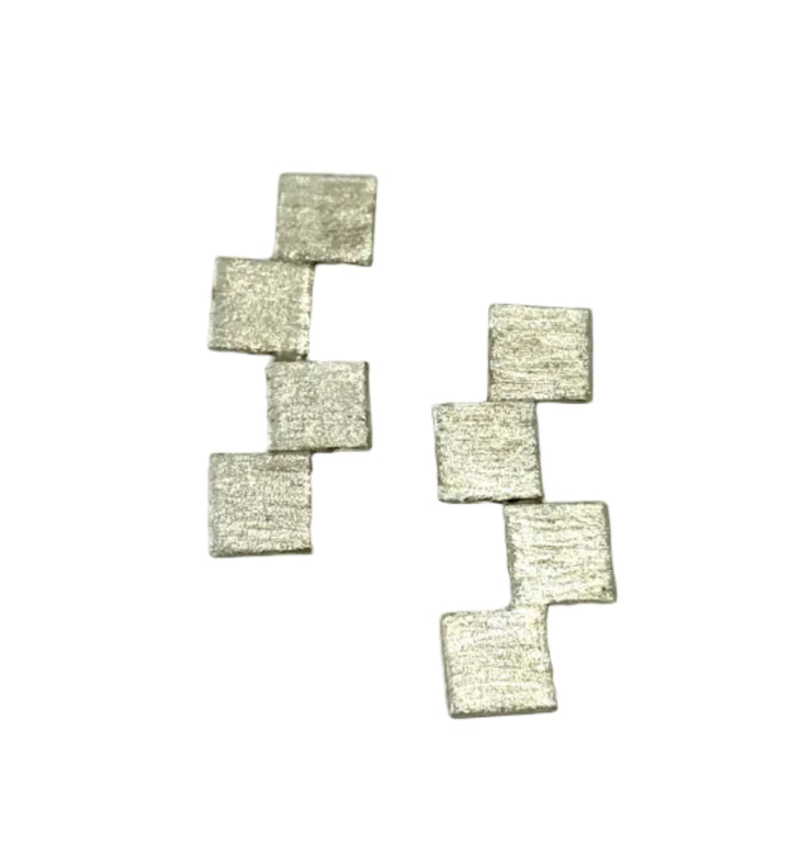 The Stairway to Heaven Earrings - Large by Soufana Attia are silver earrings with four small, staggered square plates in a vertical pattern, creating subtle asymmetry against a plain white background.