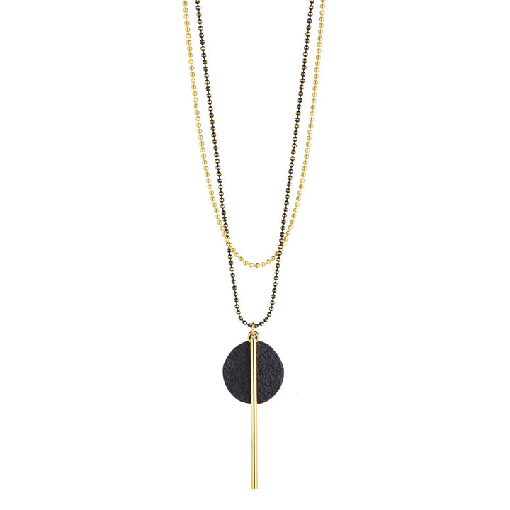 Two chains one black one gold with black circular pendant and long gold bar.