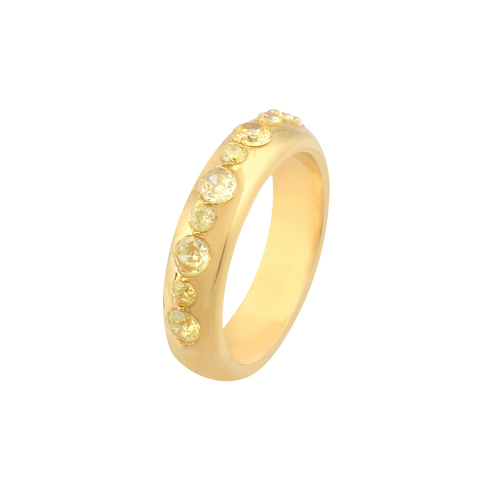 The Tasha Ring by Shyla features 22 carat gold with yellow gemstone accents forming a diagonal line along the band. The ring has a smooth, polished finish and showcases a sleek and elegant design, perfect for those seeking hypoallergenic jewelry.