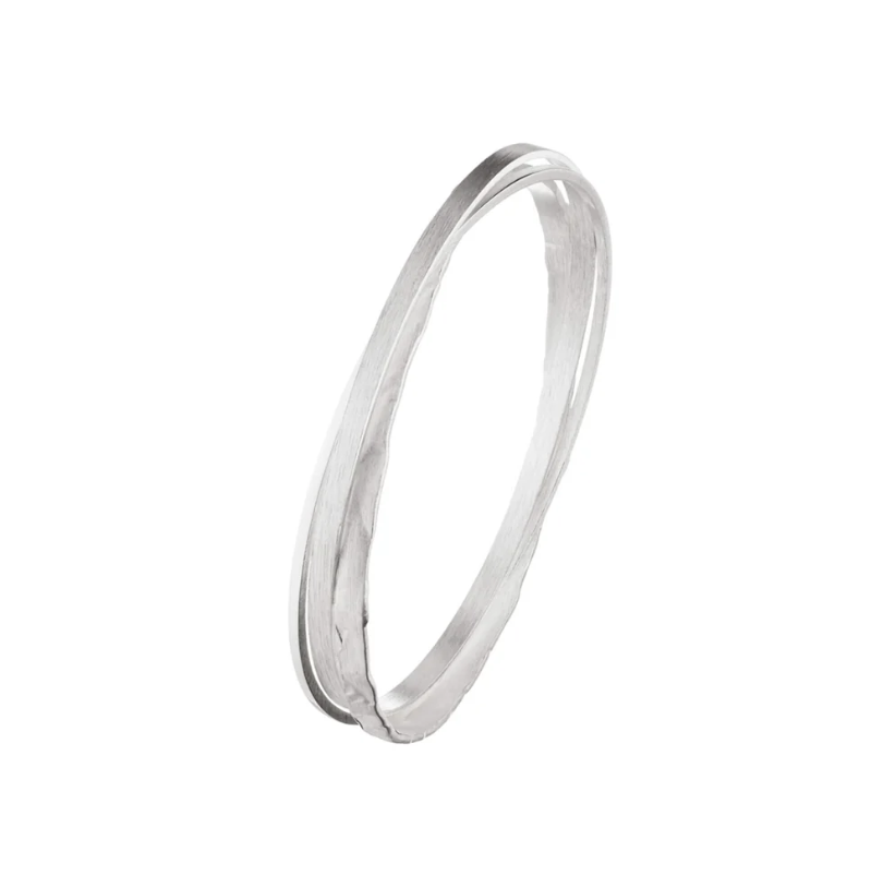 A minimalist silver bangle with three interlocking bangles on a white background.