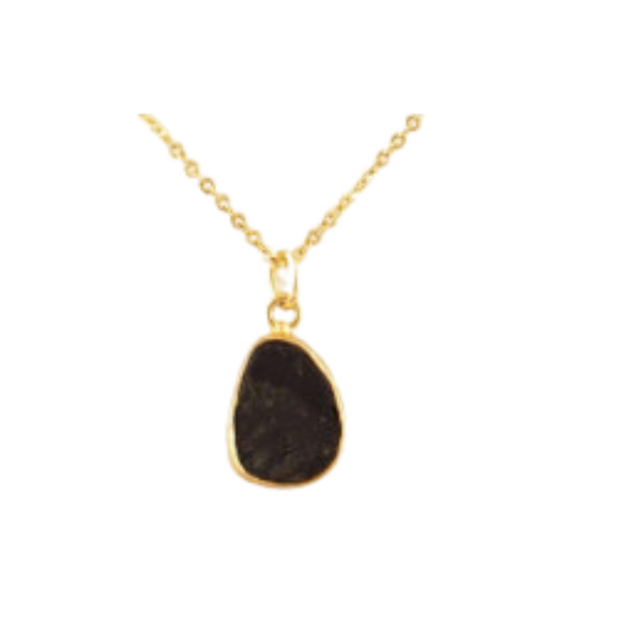 A Tuesday Tourmaline Gold Necklace by Watermelon Tropical features a pendant with an irregular black tourmaline stone encased in a gold setting. The design of the chain is delicate and simple, complementing the natural, rustic appearance of the stone.