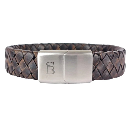 The Preston - Vintage Brown by Steel and Barnett is a genuine leather braided bracelet with a silver rectangular clasp. The clasp features an engraved stylized letter "B". The texture of the leather and the metallic sheen of the clasp provide a contrast in materials, making it a distinctive masculine accessory.