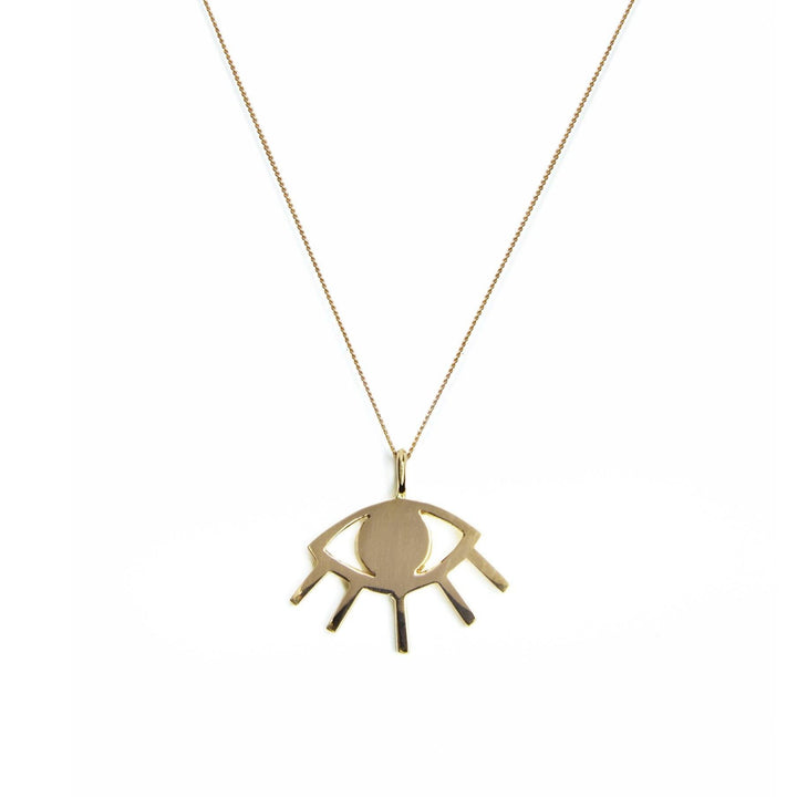 The Cosmic Boulevard 9ct Gold Evil Eye Pendant, crafted in yellow and rose gold, features a talisman pendant shaped like an abstract evil eye. The gold pendant consists of an oval center surrounded by an angular outline with small protruding lines resembling eyelashes. It hangs from a thin, gold chain against a plain white background.