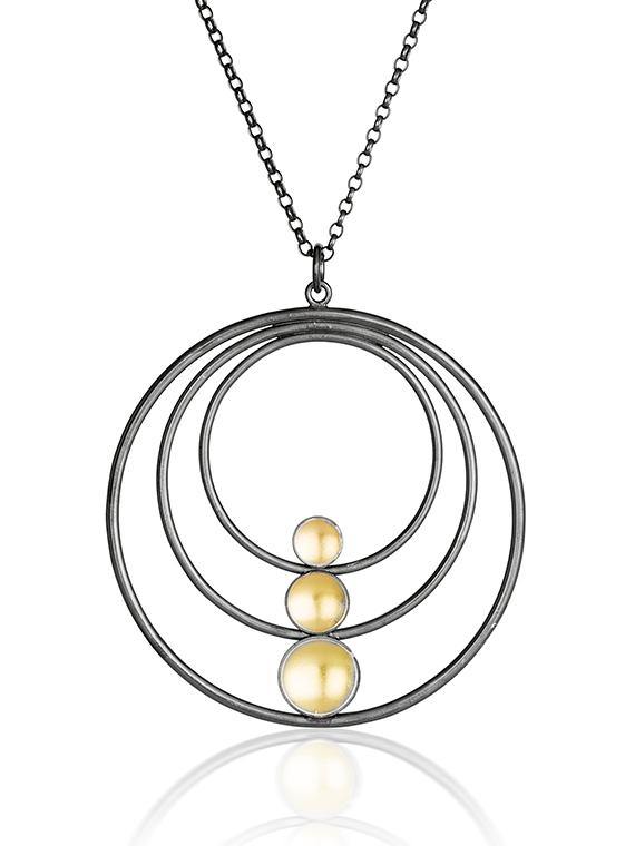 A **Fiona Kerr Black & Gold Large Pendant**. The pendant features three concentric, oxidized silver rings of increasing size with three yellowish spherical beads arranged vertically in the center, increasing in size from top to bottom on a 22ct yellow gold chain.