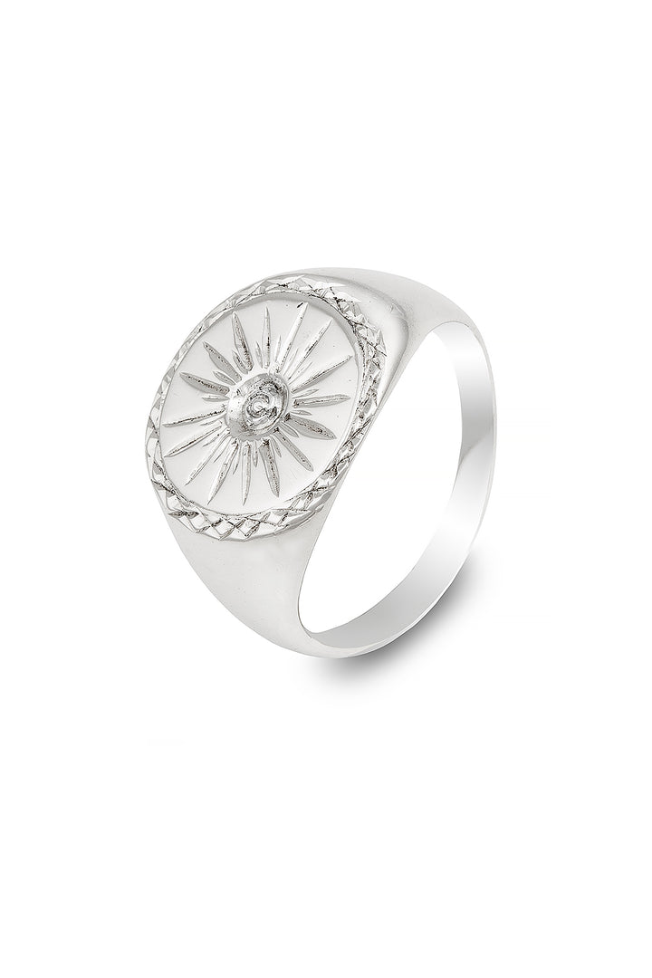 A sterling silver signet ring featuring an engraved sunburst design on an oval face. The intricate detailing around the design highlights the craftsmanship. The band is smooth and polished, giving this Starburst Silver Signet Ring by Cosmic Boulevard a sleek and elegant appearance.