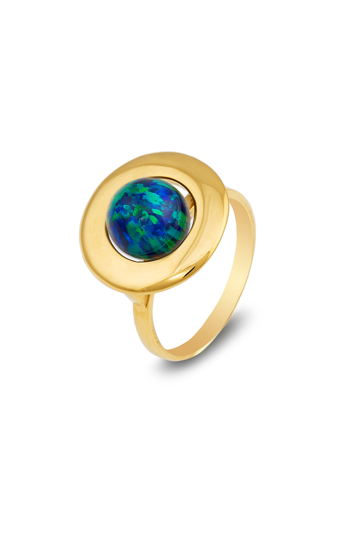 A gold ring features a round bezel setting holding a Home Planet Night Sky Opal 9ct Gold with iridescent patterns by Cosmic Boulevard. The setting is slightly elevated on a smooth, polished gold band. The ring casts a soft shadow on a white background.