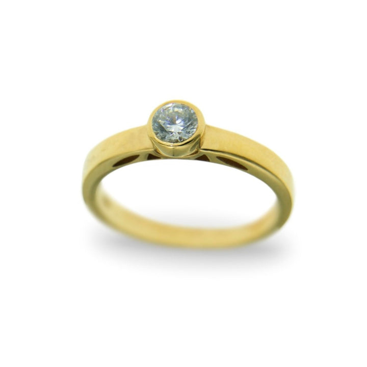 A gold solitaire ring with a simple band design, featuring a single round-cut lab grown diamond set in a bezel setting at the center. The image shows the **Miriam Wade Inagh - Solitaire Engagement Ring** on a plain white background, highlighting its elegant and minimalist style—perfect as an engagement ring.