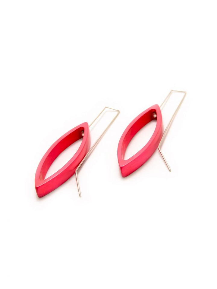 A pair of red, oval-shaped Small Navette Drop Earrings with a minimalist design from Filip Vanas. Each earring has an anodized aluminum rectangular wire passing through the oval, forming the hook for wearing. The earrings are placed side by side on a white background.