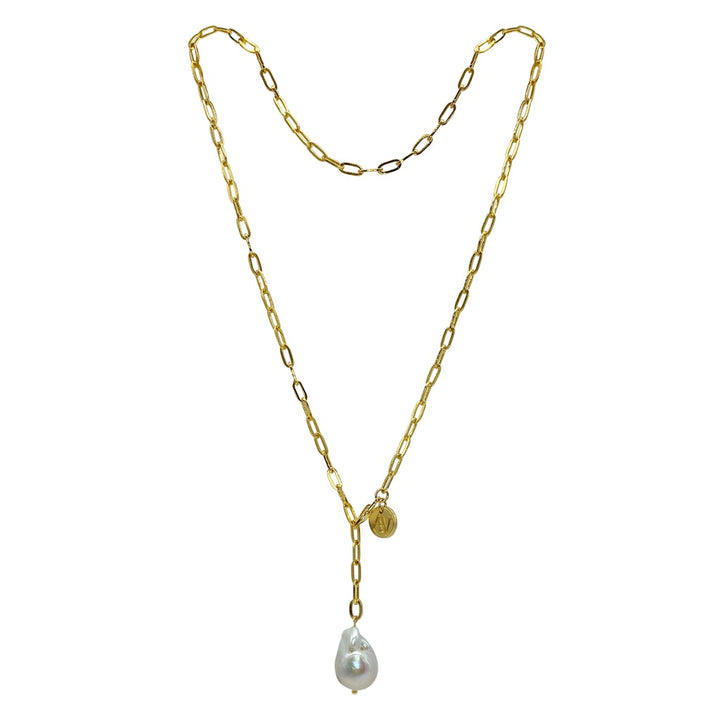 Introducing the Medea Necklace/Bracelet by Aria V: a delicate 16k gold electroplated chain with elongated links, showcasing a stunning baroque white pearl teardrop pendant and a small, round gold charm near the top.