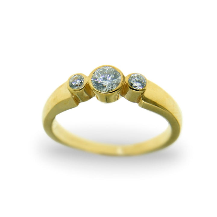 A Miriam Wade Síleann - Three Stone Engagement Ring with three round cut lab grown diamonds set on a plain gold band. The center diamond is larger, flanked by two smaller diamonds on either side. The ring is positioned against a white background.