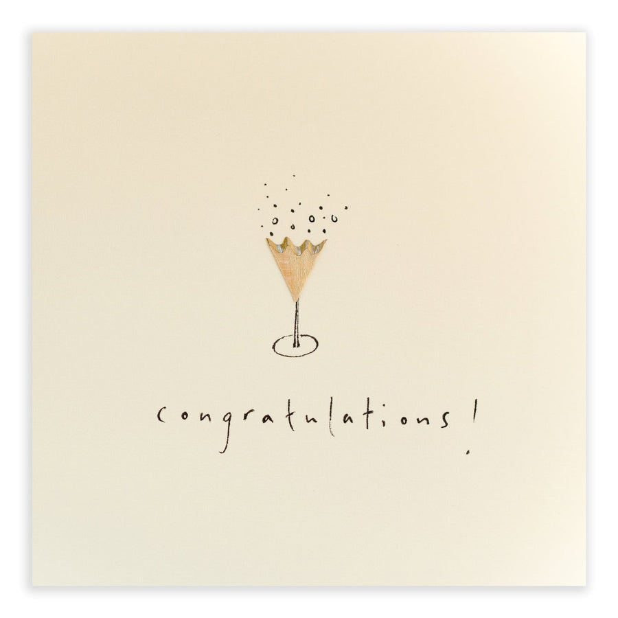 A minimalist 'Congratulations' card by Card Boutique features an illustration of a champagne flute with bubbles rising above it. Below the illustration, the word "congratulations!" is written in a casual, handwritten style. The background is plain, emphasizing the simple design. The card is cello wrapped for protection.