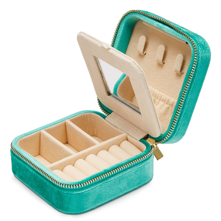 A small turquoise velvet jewelry box with a gold zipper partially open. The interior is beige and has multiple compartments, a ring holder, and an integrated mirror on the inside of the lid—perfect for travel jewellery storage. This is the Luxurious Turquoise Velvet Travel Jewellery Box by SoCases.