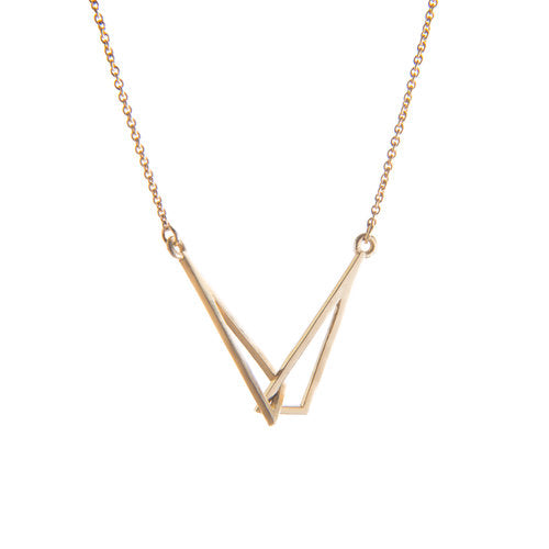 A minimalist Le Cheile Pendant Small 9ct Yellow Gold with a geometric design hangs on a delicate chain. The interconnected triangular shapes form a unique, abstract pattern. The plain white background highlights the simplicity and elegance of this dainty jewellery, perfect for celebrating a special relationship. This exquisite piece is crafted by Miriam Wade.