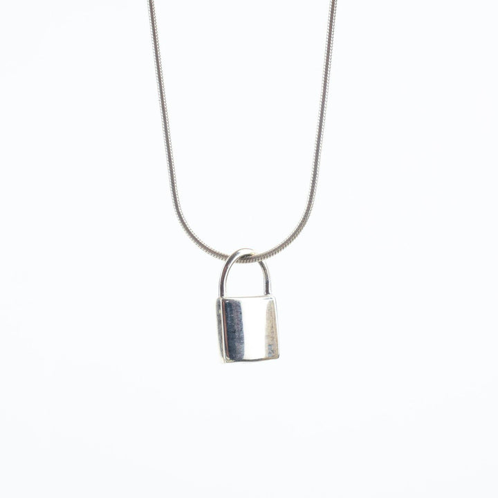 A Small Sterling Silver Lock by Engravable Jewellery hangs against a plain white background. The simplicity of the design gives it a minimalist and modern appearance, enhanced by its adjustable chain.