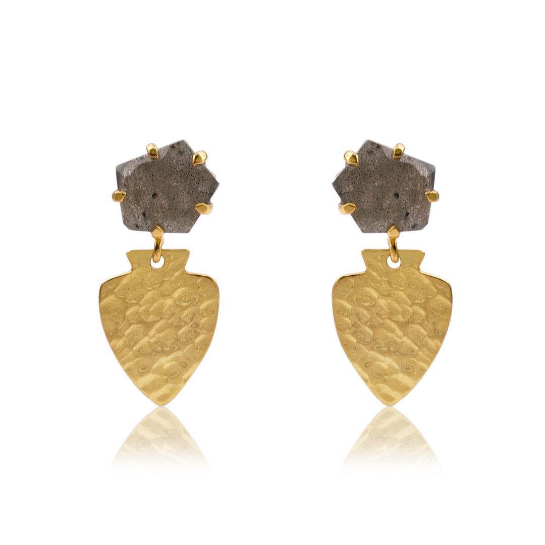 A pair of Labradorite Hammered Gold Shield Earrings from Watermelon Tropical featuring gold vermeil shield-shaped pendants with a hammered texture, each attached to an irregularly shaped labradorite stone set in a gold-tone frame. The earrings have a sophisticated and elegant design.