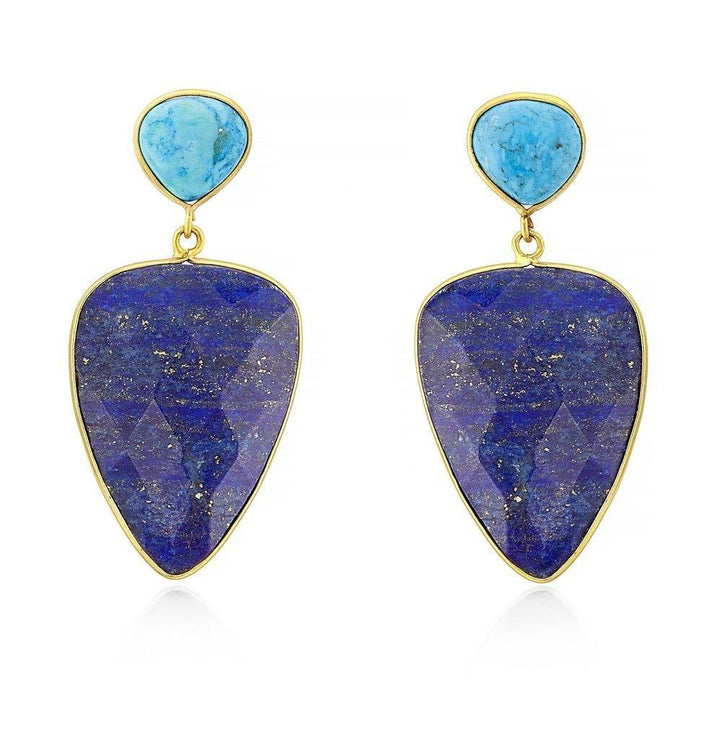 The Abi Earrings by Aria V are a pair of statement earrings featuring triangular turquoise stones at the top and larger, inverted trapezoidal lapis lazuli stones framed in gold below. The lapis lazuli stones have a deep blue color with specks of gold, making them truly eye-catching.