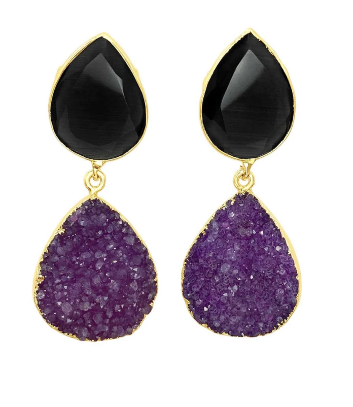 The Aria V Black Magic Earrings feature teardrop-shaped black gemstones at the top, paired with teardrop-shaped purple Druze stones at the bottom, all framed in 16k gold-plated brass. The upper stone is smooth and faceted, while the lower stone boasts a rough, textured surface.