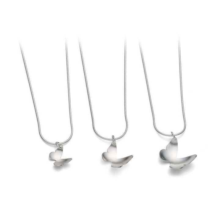 Three Butterfly Pendant Silver necklaces by Leoma Drew feature sleek, modern pendants shaped like abstract, stylized birds. The fine, smooth texture of the silver snake chains complements the handcrafted elegance of each piece. The image is set against a plain white background.